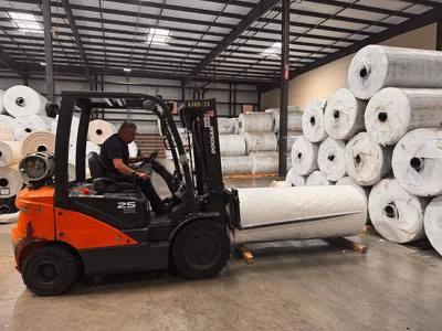 Forklift Operator Handling Warehouse Rolls